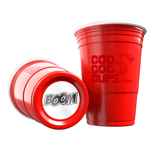 Two red CooCoo Cups® are shown. One displays the logo while the other lies on its side, revealing a bottom sticker featuring “BOOM” text.