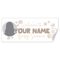 A personalized baby shower banner or sign with a white background, featuring the text 'Welcome to YOUR NAME Baby Shower' in beige and gray lettering, decorated with stars, a rattle, a pacifier, a teddy bear, a placeholder circle photo area and a curled lower-right corner.