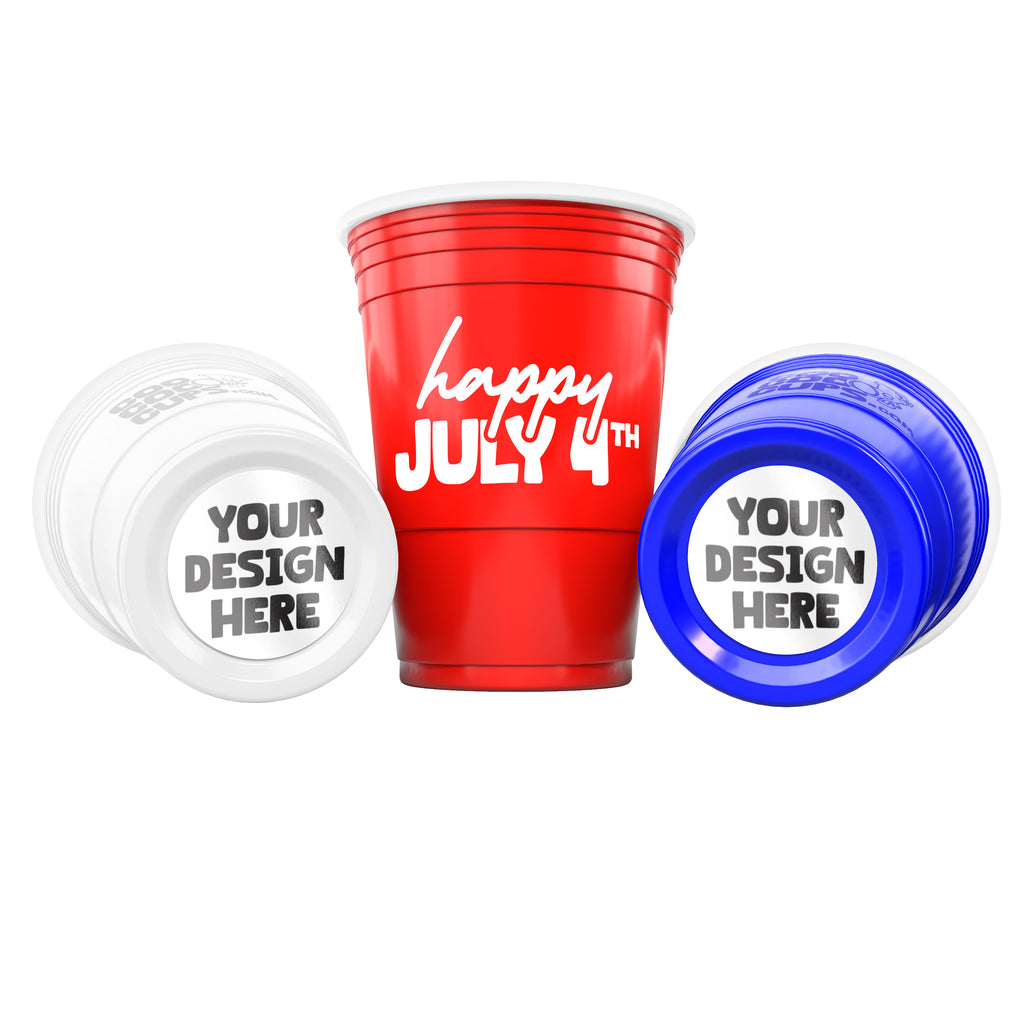 Three CooCoo Cups® are shown in red, white, and blue. One displays the white text “Happy July 4th!” while the other two lie on their sides, revealing customizable bottom stickers labeled “Your Design Here.”